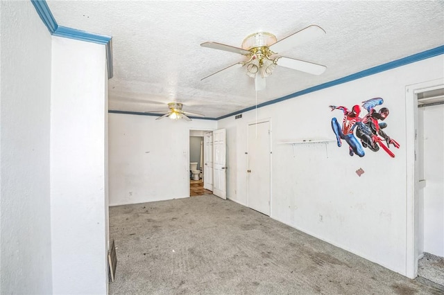 empty room featuring ornamental molding, carpet flooring, ceiling fan, and a textured ceiling