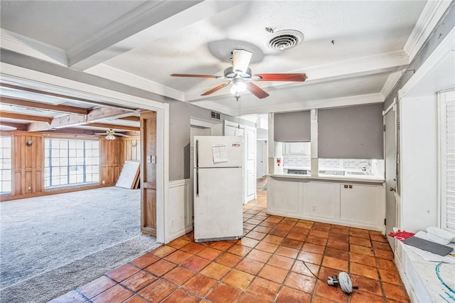 kitchen with light carpet, visible vents, freestanding refrigerator, crown molding, and beam ceiling