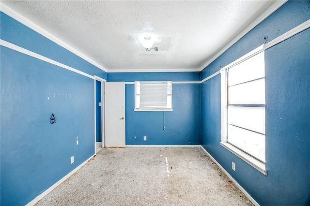 carpeted spare room featuring baseboards and a textured ceiling