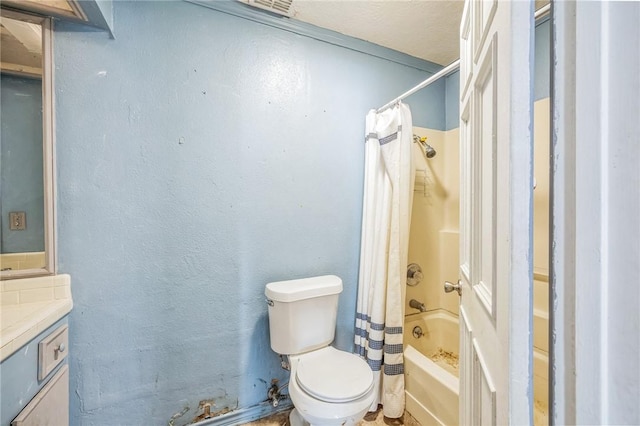 bathroom featuring toilet, a textured wall, shower / tub combo with curtain, and vanity