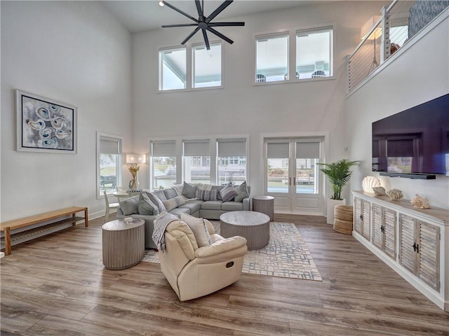 living area with ceiling fan, french doors, wood finished floors, and baseboards