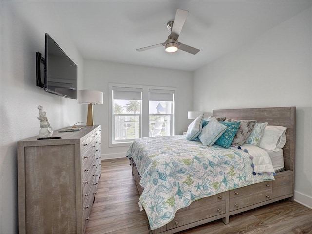 bedroom with a ceiling fan, baseboards, and wood finished floors