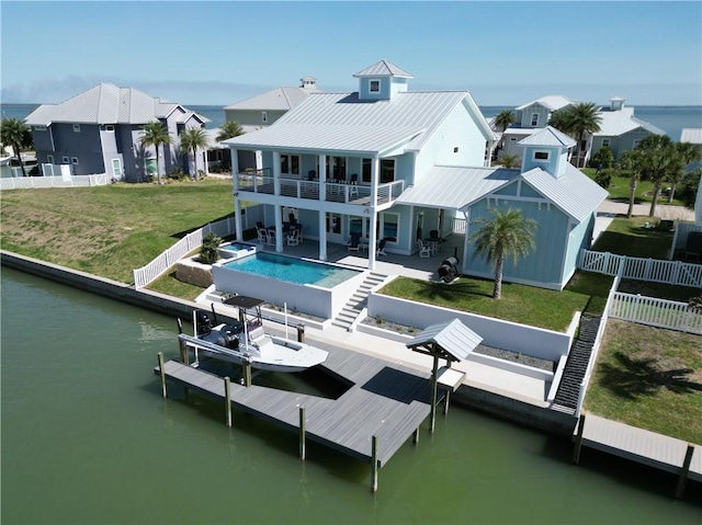 back of house featuring a fenced in pool, boat lift, a water view, a lawn, and a balcony