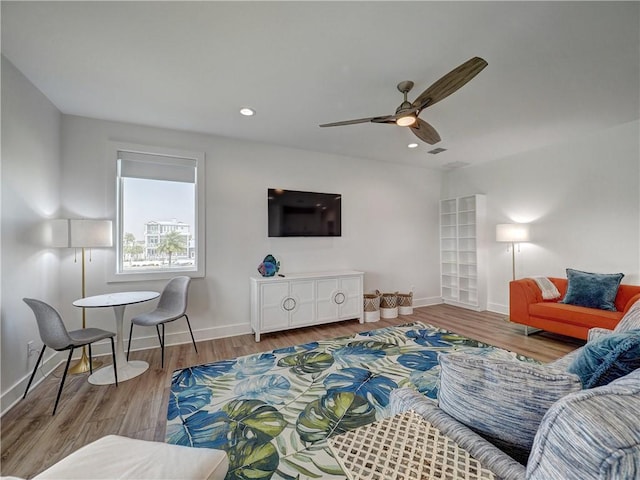 living area with a ceiling fan, baseboards, wood finished floors, and recessed lighting