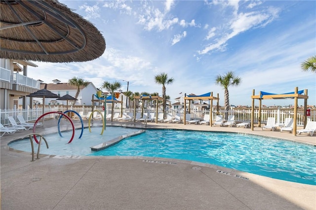 view of swimming pool featuring a patio area and fence