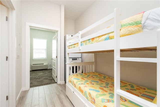 bedroom with a wall mounted air conditioner and wood tiled floor