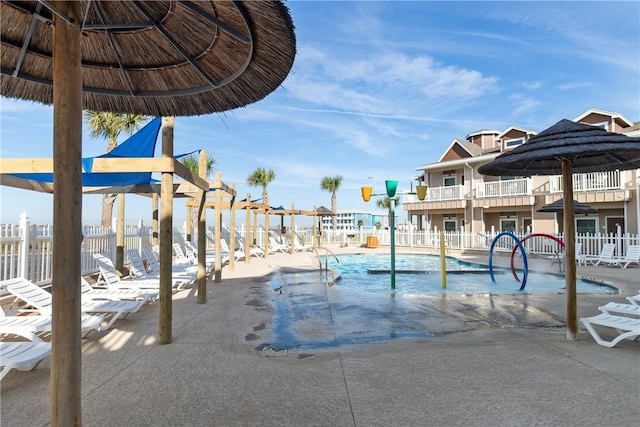 pool with a patio and fence