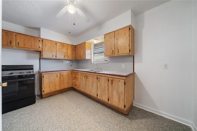 4613 Marks Dr, Corpus Christi, TX 78411 - kitchen with black gas range oven, decorative backsplash, a ceiling fan, tile counters, and a textured ceiling