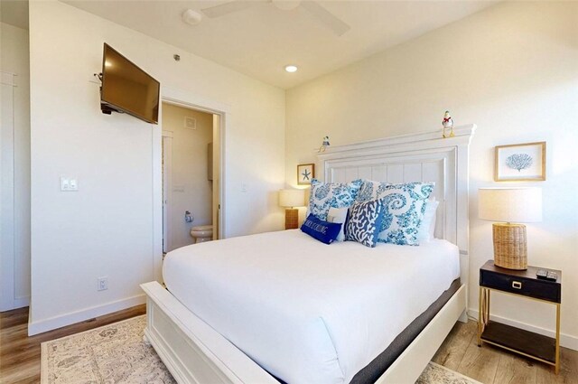 bedroom featuring ensuite bathroom, ceiling fan, and light hardwood / wood-style flooring