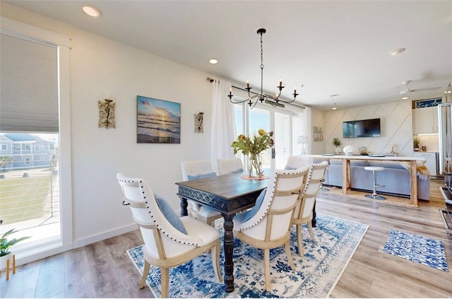 dining room with light wood-type flooring and a chandelier