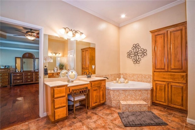 bathroom with tiled bath, vanity, and ornamental molding