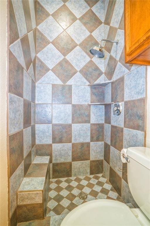 bathroom featuring toilet and a tile shower