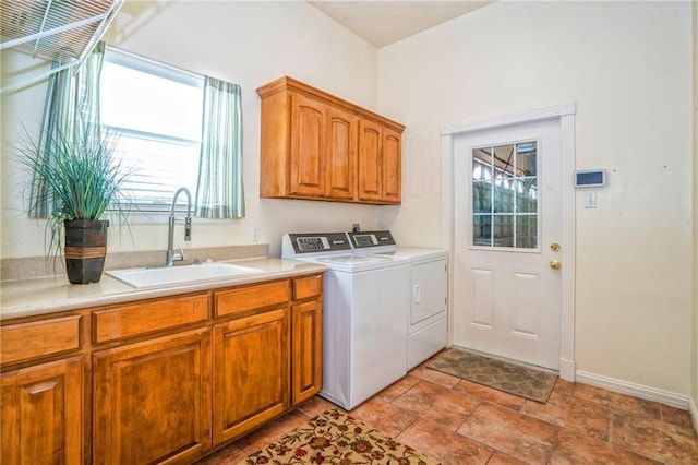 laundry area with washing machine and dryer, sink, and cabinets