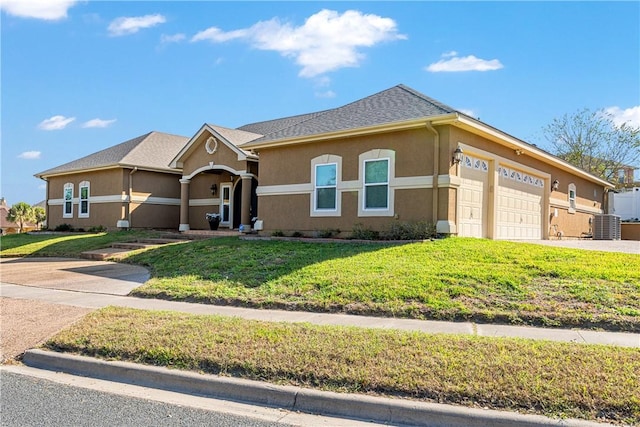 view of front of home with a garage, cooling unit, and a front lawn