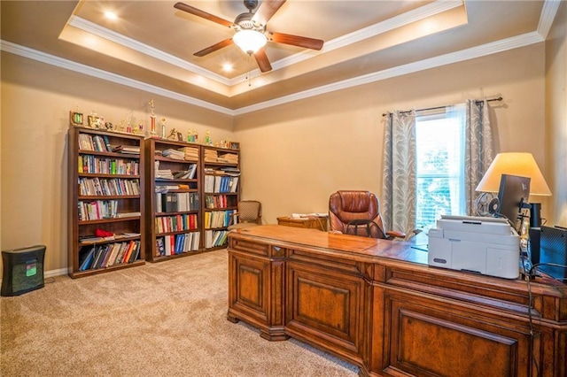 carpeted home office with a raised ceiling, ceiling fan, and ornamental molding