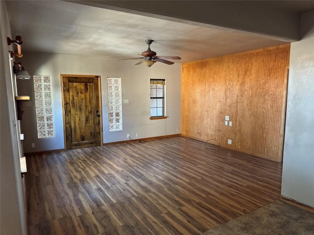 foyer featuring ceiling fan, wooden walls, and dark hardwood / wood-style flooring