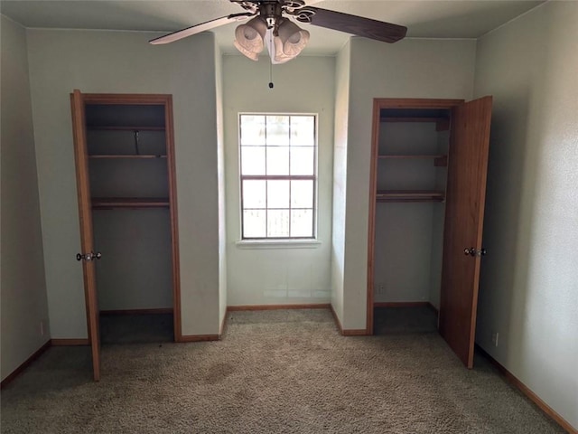 unfurnished bedroom featuring ceiling fan, multiple closets, and carpet