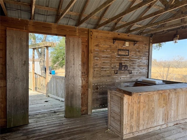 bar featuring vaulted ceiling, hardwood / wood-style floors, and light brown cabinetry