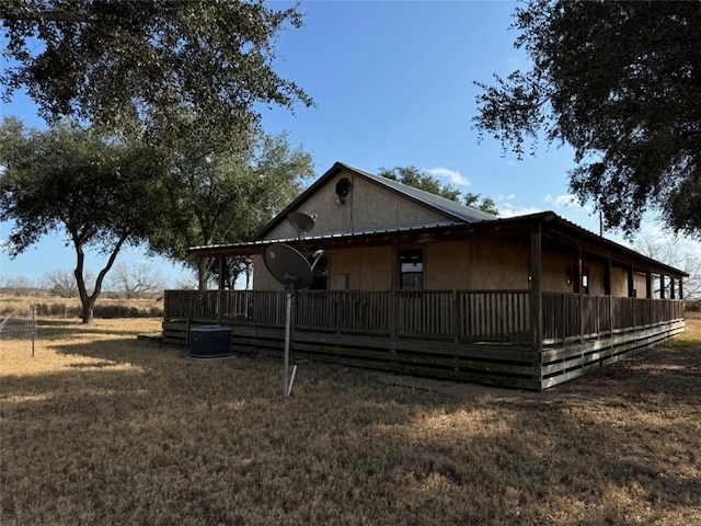 view of side of property featuring central AC and a lawn