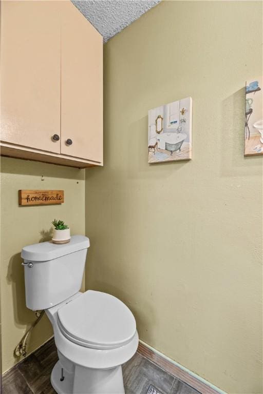 bathroom featuring toilet and baseboards