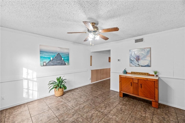 sitting room featuring visible vents, ornamental molding, ceiling fan, a textured ceiling, and tile patterned flooring