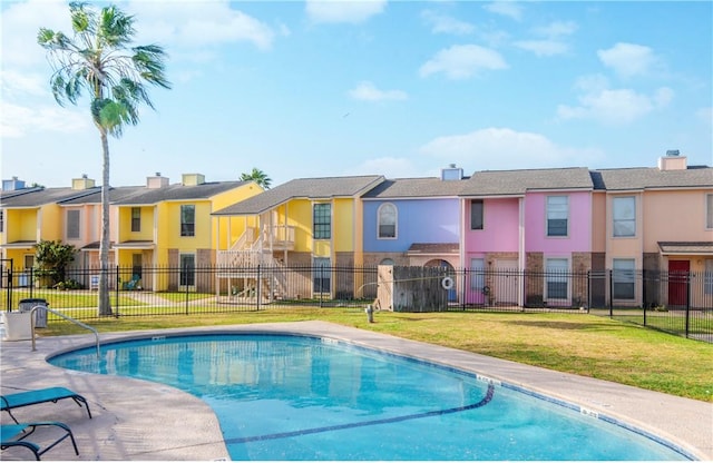 community pool featuring a residential view, fence, and a yard