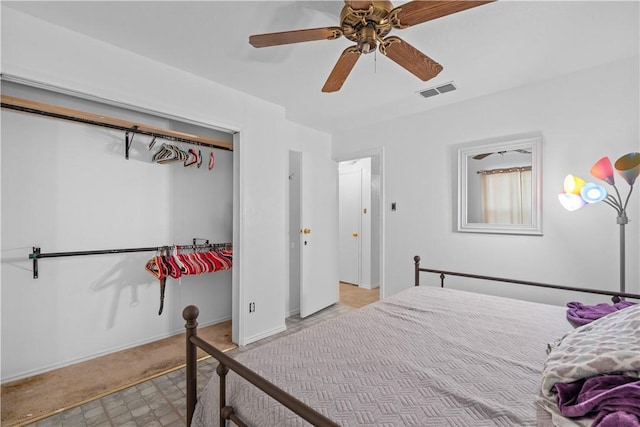 bedroom featuring baseboards, visible vents, a ceiling fan, light colored carpet, and a closet