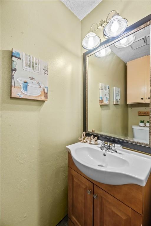 half bathroom with vanity and toilet