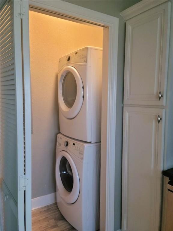 14802 Whitecap Blvd Unit 3-106, Corpus Christi, TX 78418 - laundry area featuring stacked washer / drying machine and light wood-style flooring