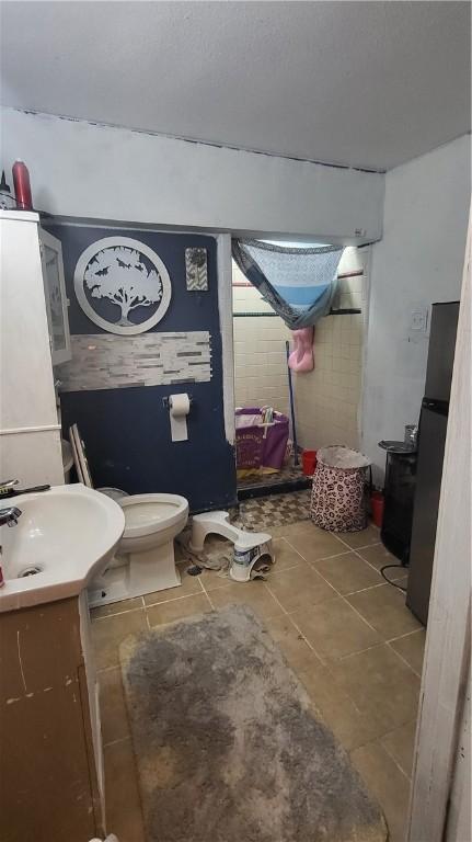 bathroom featuring vanity, toilet, and tile patterned floors