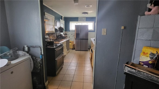 kitchen featuring light tile patterned flooring, a sink, visible vents, light countertops, and appliances with stainless steel finishes