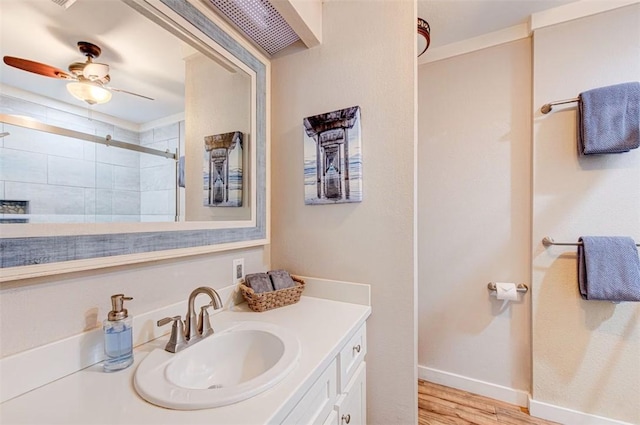 3 Mazatlan Dr, Rockport, TX 78382 - bathroom featuring a tile shower, wood finished floors, vanity, baseboards, and ceiling fan