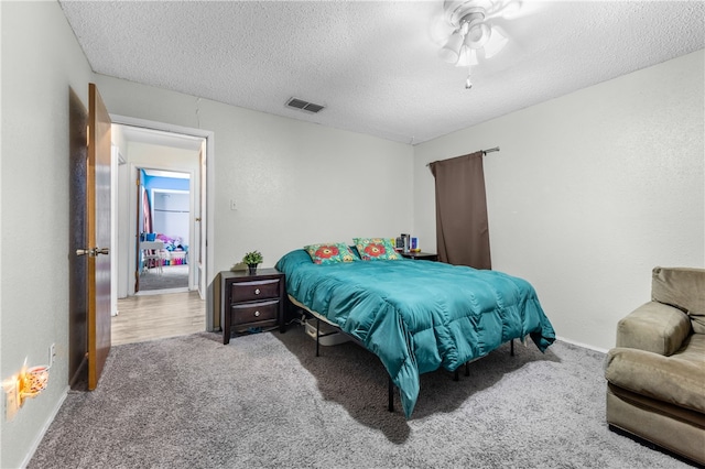 carpeted bedroom with a textured ceiling and ceiling fan