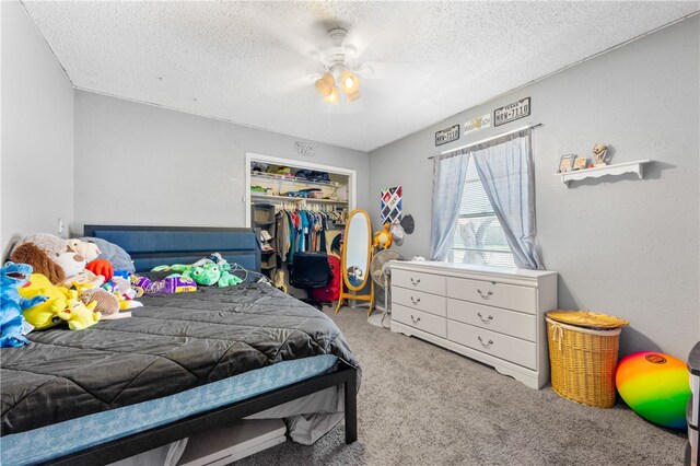 carpeted bedroom with a textured ceiling, ceiling fan, and a closet