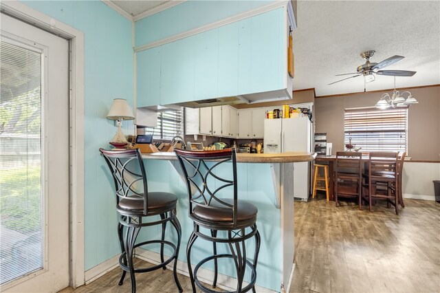 kitchen featuring a wealth of natural light, white cabinetry, and white fridge with ice dispenser