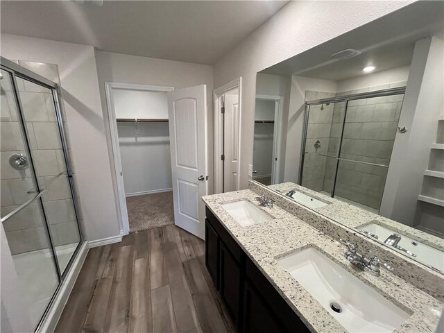 7302 Wilder Ln, Corpus Christi, TX 78414 - full bath with a walk in closet, wood finished floors, a shower stall, and double vanity