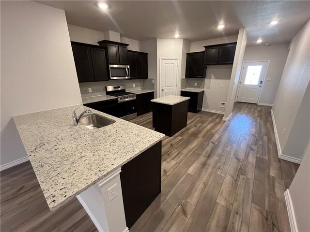 7302 Wilder Ln, Corpus Christi, TX 78414 - kitchen featuring appliances with stainless steel finishes, a peninsula, a center island, dark wood-style floors, and dark cabinets