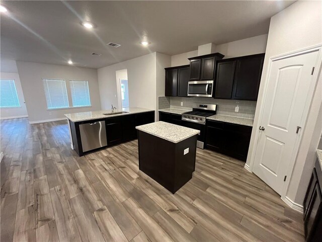 7302 Wilder Ln, Corpus Christi, TX 78414 - kitchen with appliances with stainless steel finishes, dark cabinetry, a peninsula, light wood-type flooring, and recessed lighting