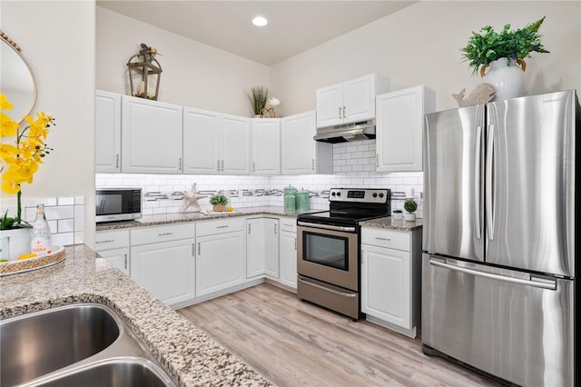 115 N Nautica, Rockport, TX 78382 - kitchen with appliances with stainless steel finishes, under cabinet range hood, white cabinetry, decorative backsplash, and recessed lighting