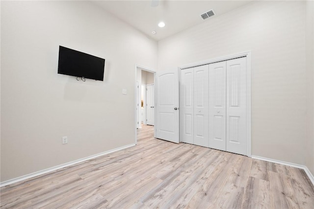 115 N Nautica, Rockport, TX 78382 - unfurnished bedroom featuring baseboards, light wood-style floors, a closet, recessed lighting, and a towering ceiling