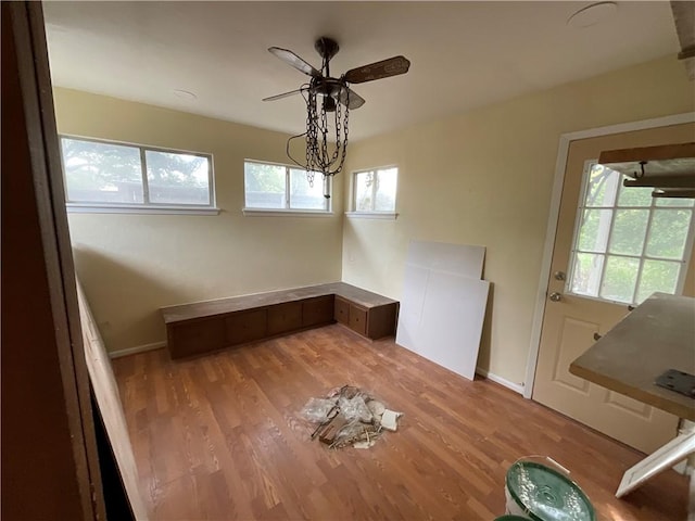 unfurnished dining area featuring baseboards, light wood finished floors, and ceiling fan