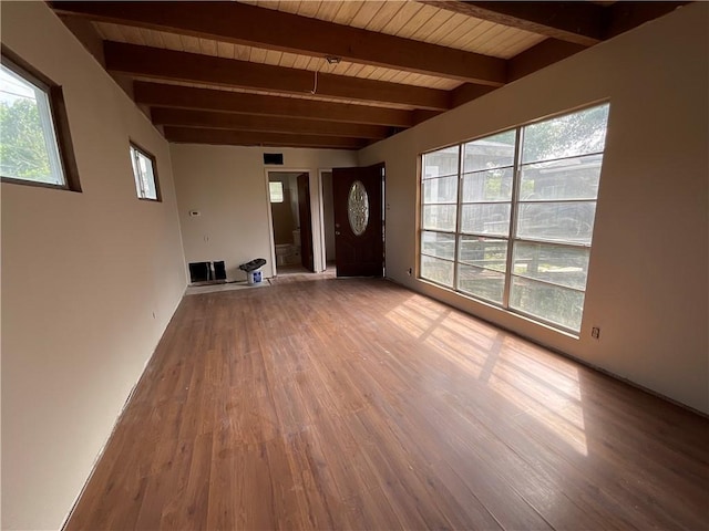 unfurnished living room with beam ceiling, wooden ceiling, and wood finished floors