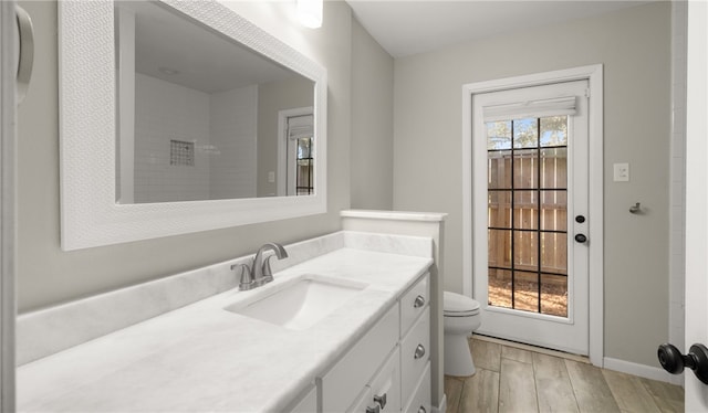 bathroom featuring toilet, vanity, and hardwood / wood-style flooring