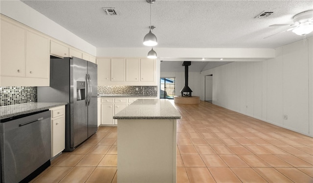 kitchen featuring appliances with stainless steel finishes, backsplash, a center island, wooden walls, and pendant lighting