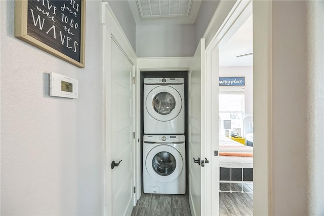 70 Belaire Dr, Rockport, TX 78382 - laundry room with laundry area, stacked washing maching and dryer, baseboards, wood finished floors, and visible vents