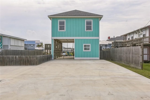 70 Belaire Dr, Rockport, TX 78382 - back of property with board and batten siding, fence, driveway, and a shingled roof