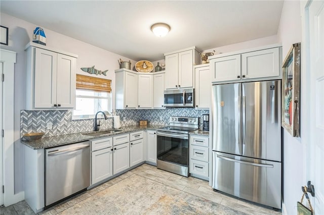 70 Belaire Dr, Rockport, TX 78382 - kitchen with dark stone countertops, appliances with stainless steel finishes, a sink, and tasteful backsplash