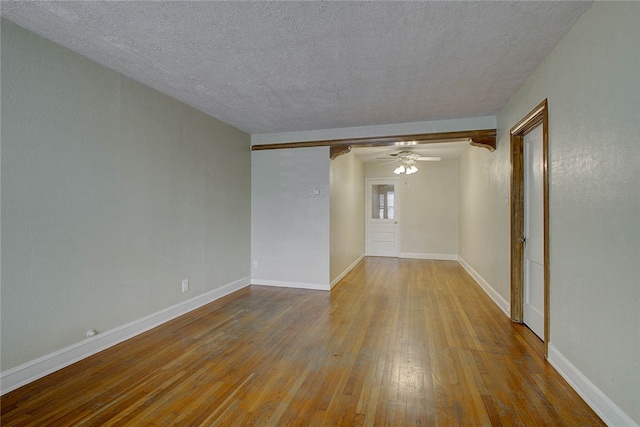 empty room featuring a textured ceiling, hardwood / wood-style flooring, and ceiling fan