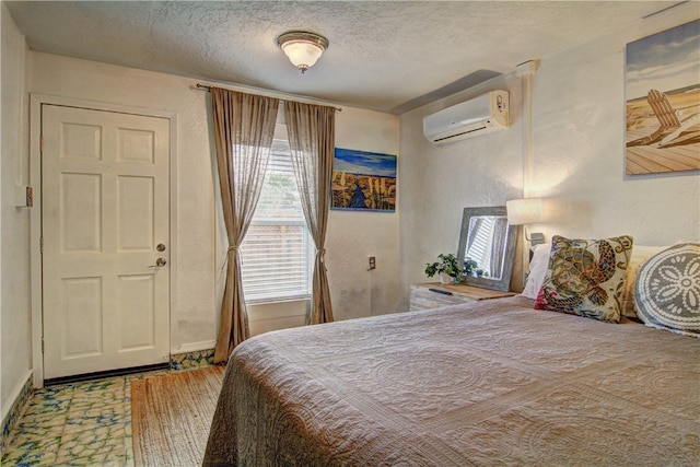 bedroom with a wall mounted AC and a textured ceiling