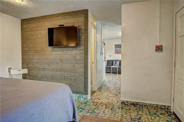 bedroom with wood walls and a textured ceiling